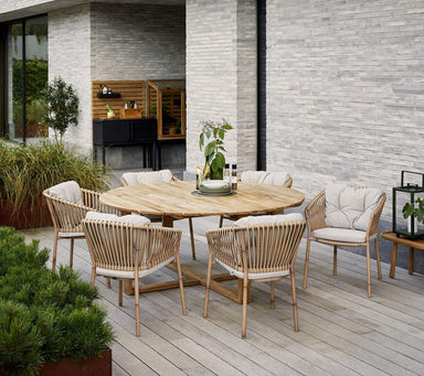 Boxhill's Endless Outdoor Round Dining Table lifestyle image with 6 dining chairs at patio