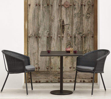 Boxhill's Go Outdoor Square Aluminum Cafe Table lifestyle image with 2 dining chairs beside vintage wardrobe