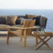 Boxhill's Amaze Stackable Lounge Teak Chair lifestyle image on wooden platform at the beach side 