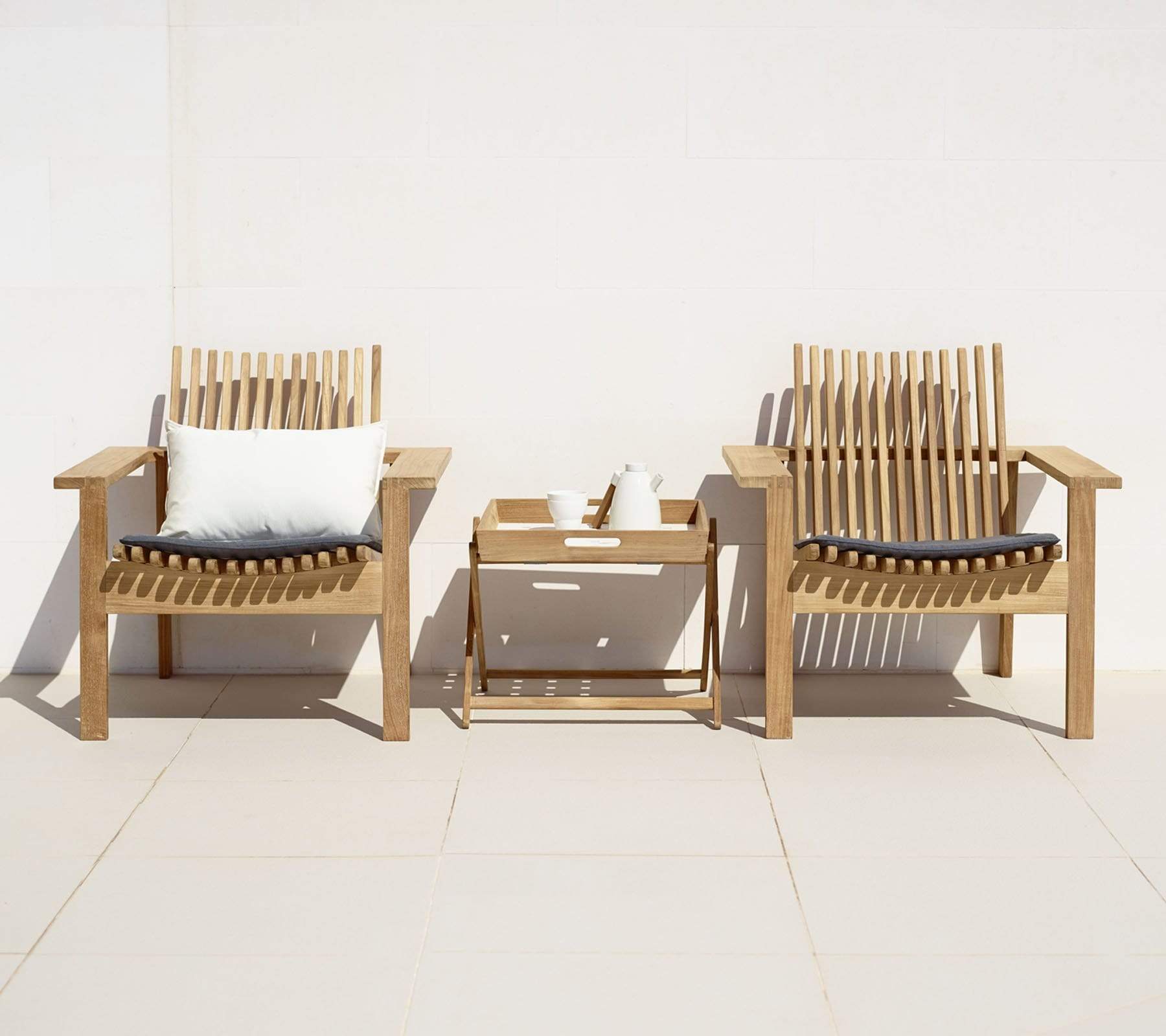 Boxhill's Amaze Stackable Lounge Teak Chair lifestyle image with cushion