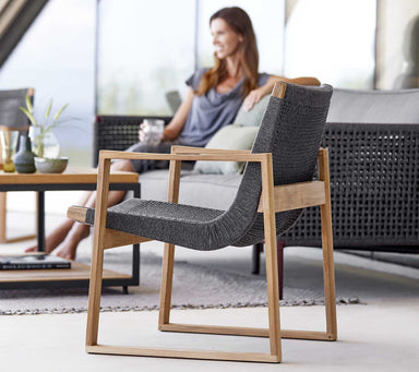Boxhill's Endless Outdoor Lounge Chair lifestyle image with a woman sitting on a 3-seater sofa