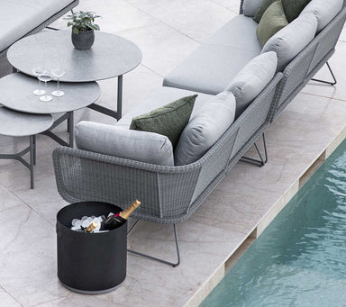   Boxhill's lava grey outdoor round small modern planter box with light grey outdoor sectional sofa placed beside the pool
