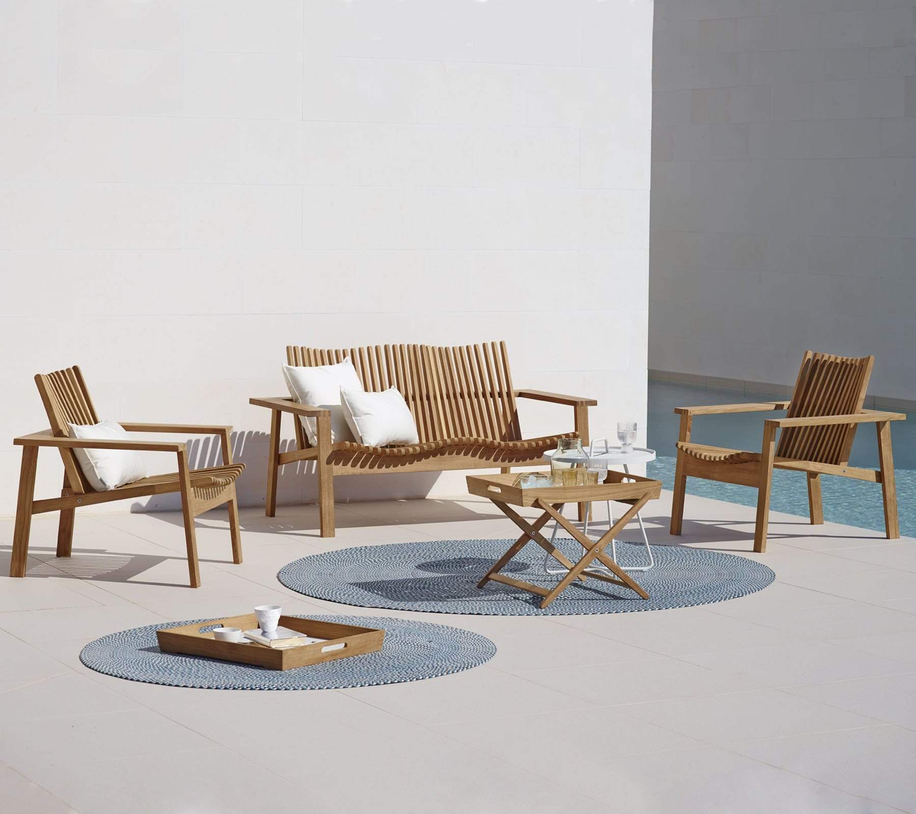 Boxhill's Amaze 2-Seater Teak Sofa lifestyle image with amaze lounge chair beside the pool