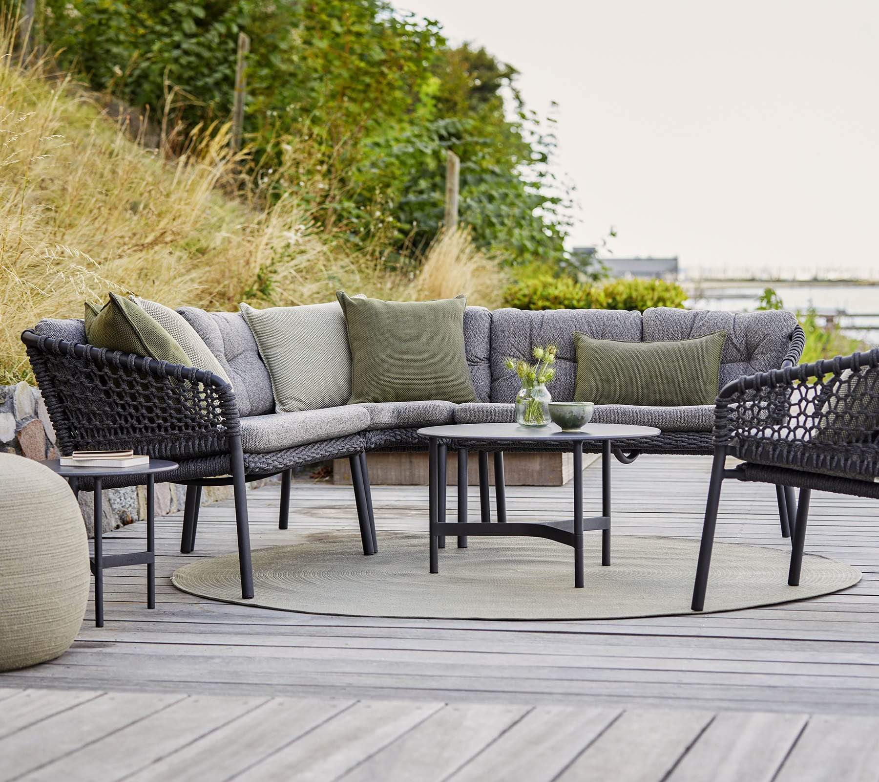 Boxhill's Ocean 2-Seater Outdoor Left Module Sofa lifestyle image on wooden platform with other Ocean Module Sofa Collection and a round table 