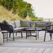 Boxhill's Ocean 2-Seater Outdoor Left Module Sofa lifestyle image on wooden platform with other Ocean Module Sofa Collection and a round table 