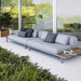 Boxhill's Space light grey outdoor sectional sofa with teak side table top set against glass wall with teak planter box at the side