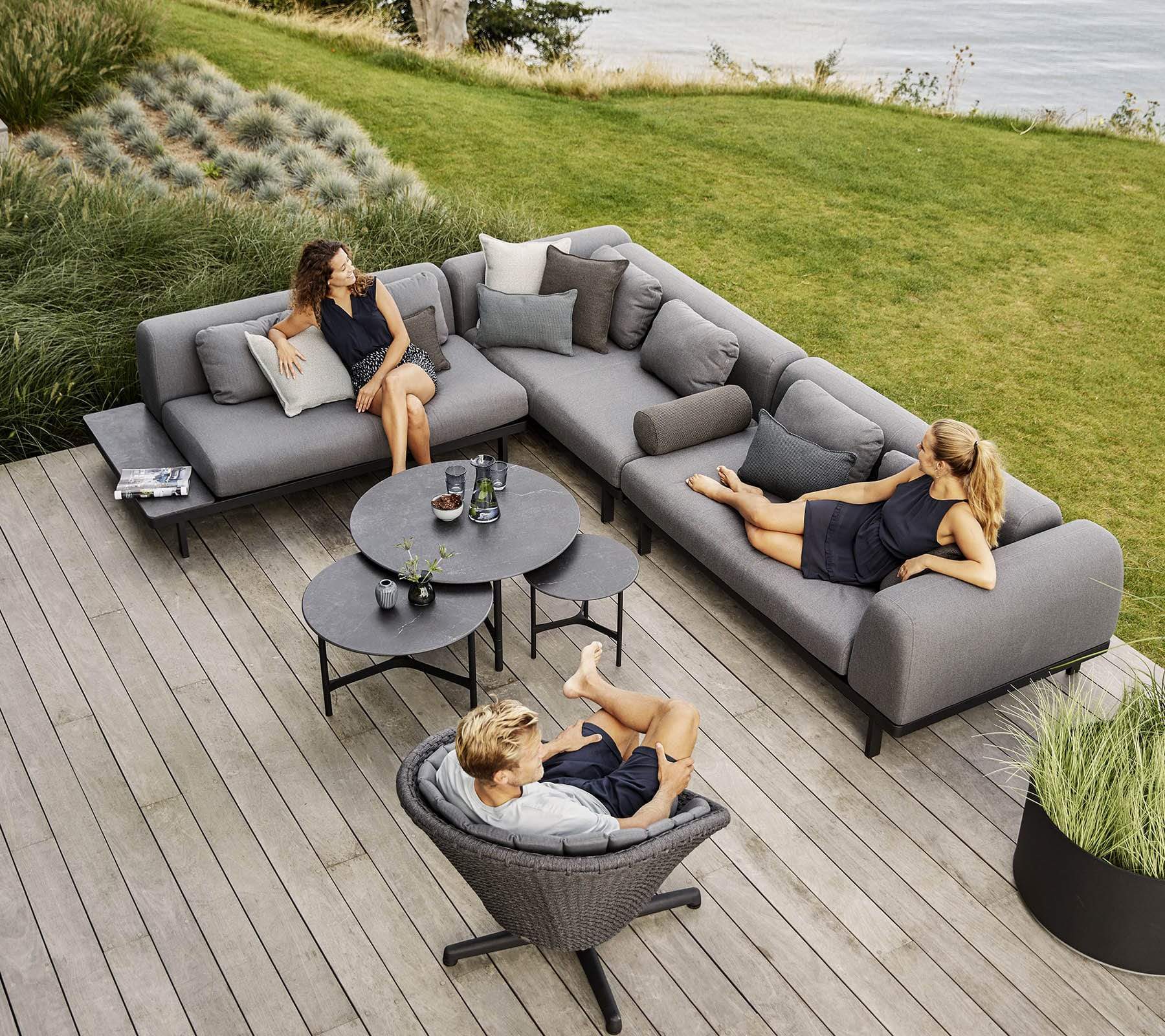 Boxhill's Space light grey outdoor sectional sofa with 3 black round table and grey outdoor lounge chair set on wooden patio
