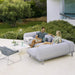 Boxhill's Space light grey outdoor sectional sofa with grey lounge chair and white square table set on outdoor patio